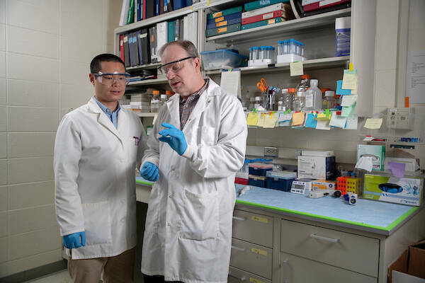 Professor Jeff Schorey speaks with Research Assistant Professor Yong Cheng in his lab in Galvin Life Science.